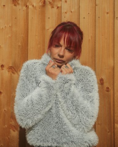model marie sporting clockwork grey fluffy hoody Dave Waddicor Photography - Retro Y2K style outdoor fashion portrait of model Marie in a textured white jacket against a wooden fence back